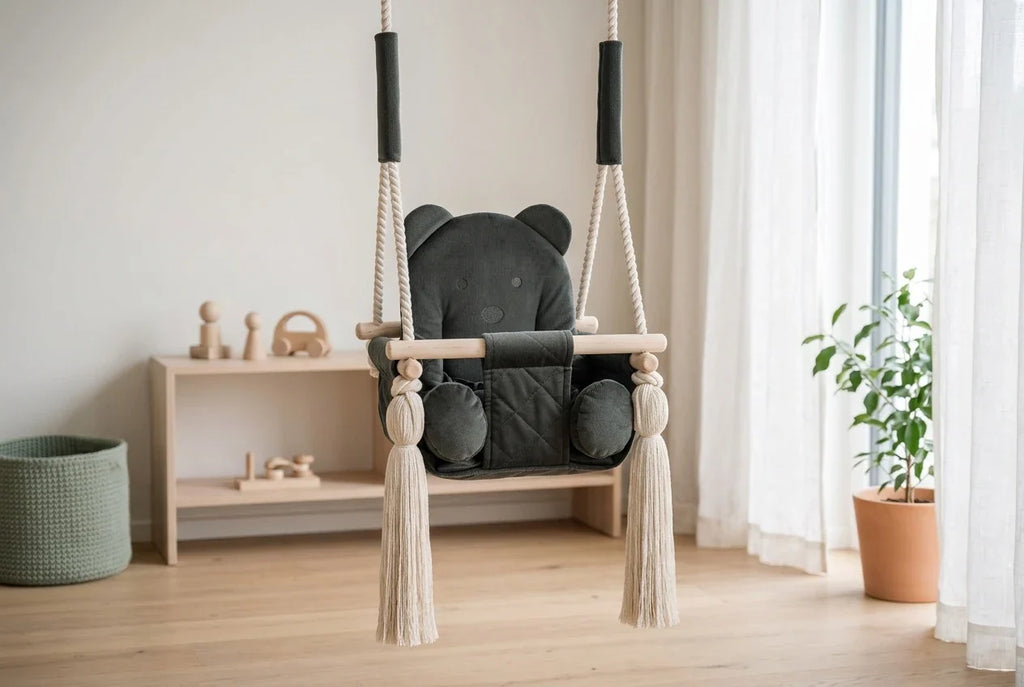 Samtschaukel mit Baermotiv in einem hellen Kinderzimmer mit niedrigem Holzregal